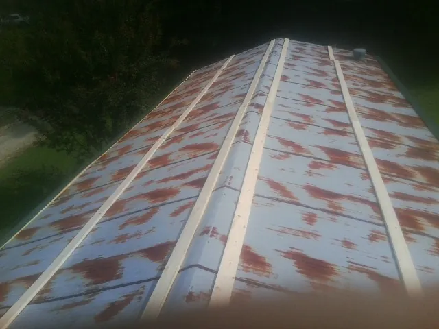 Rusted metal roof panels with new wood purlins before replacement — Storm Damage Roof Repair in Platte Center by Roofing Brothers